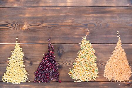 Flat lay composition with different types of grains and cereals on a wooden background. With copy space.の写真素材