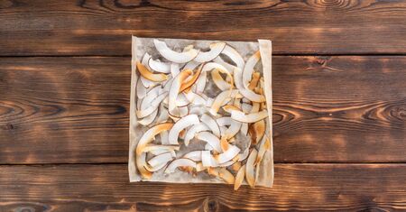 Close up view of dried coconut chips in on baking paperの写真素材
