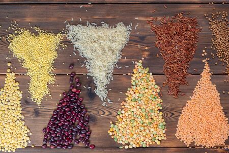 Different types of grains and cereals on a wooden background.の写真素材