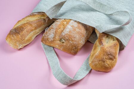 Top view of Bread in a Reusable zero waste textile bag on the pink background.