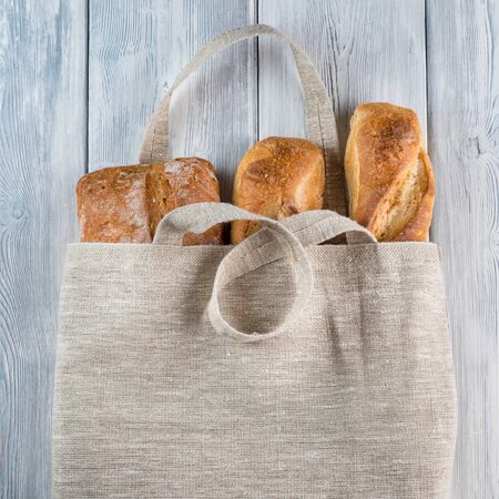 Top view of Bread in a Reusable zero waste textile bag on the wooden background.の写真素材