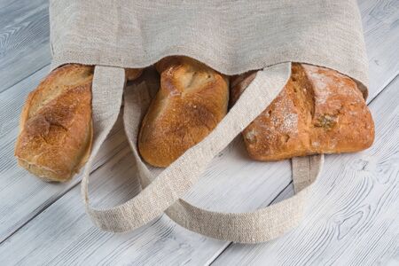 View of Bread in a Reusable zero waste textile bag on the wooden background.の写真素材