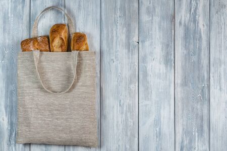 Top view of Bread in a Reusable zero waste textile bag on the white wooden background. With copy space.の写真素材