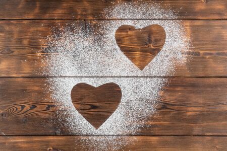 Top view of Shapes of hearts on flour on wooden backgroundの写真素材