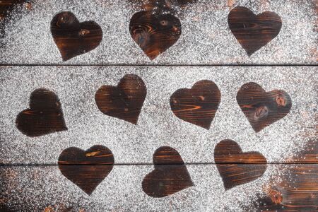Top view of Shapes of hearts on flour on red wooden backgroundの写真素材