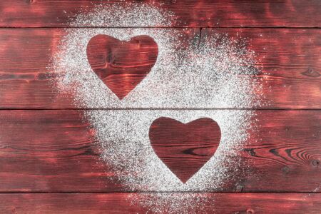 Shapes of hearts on flour on wooden backgroundの写真素材