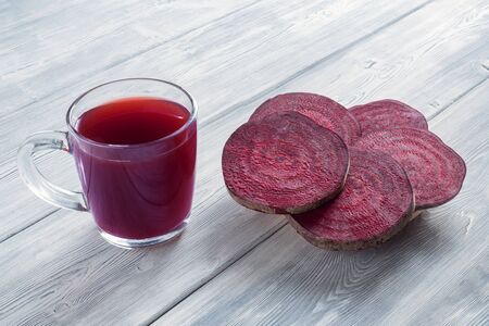 The beetroot juice with slices of beef on white wooden backgroundの写真素材