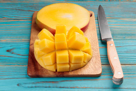 Sliced mango on a wooden board on a rustic tableの写真素材