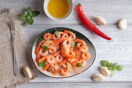 Shrimps pinchos tapas from Spain in plate with fork, red pepper, garlic, oil on white wooden rustic background.の写真素材