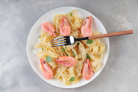 Pasta fettuccine with shrimp in rustic plate with forkの写真素材