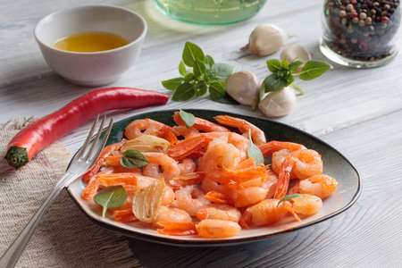 Shrimps pinchos tapas from Spain in plate with fork, red pepper, garlic, oil on white wooden rustic background.の写真素材