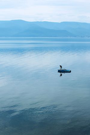 Alone fisherman on little boad in huge lakeの写真素材