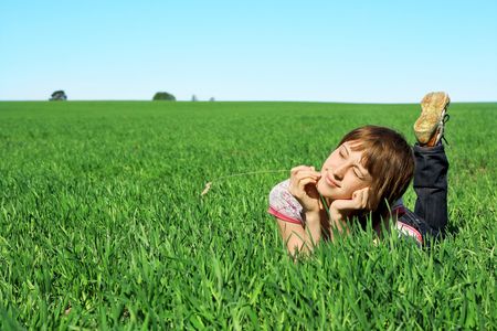 Young woman lying in green grassの写真素材