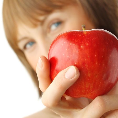 Young woman with enigmatic glance holding red appleの写真素材