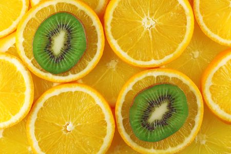 Background from green kiwi and orange slicesの写真素材
