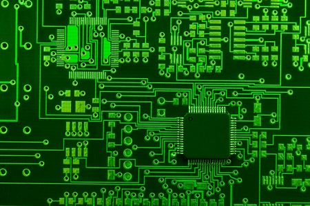 Close-up image of green board made for surface mount technology with one many-pins semiconductor componentの写真素材