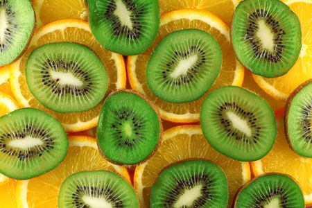 Background from green kiwi and orange slicesの写真素材