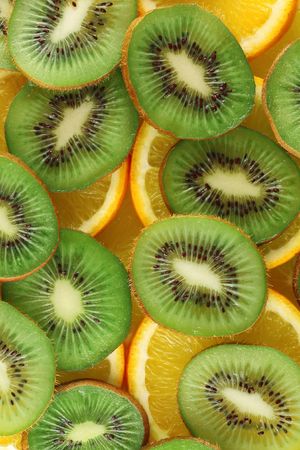 Background from green kiwi and orange slicesの写真素材