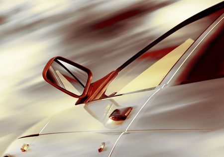 Part of a car with reflection in mirror and blurry gray sky