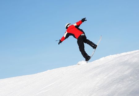 Snowboard sportsmen in jump over clear blue skyの写真素材