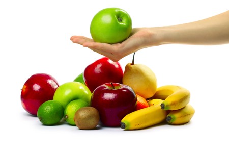 Hand with apple over heap of fruitsの写真素材