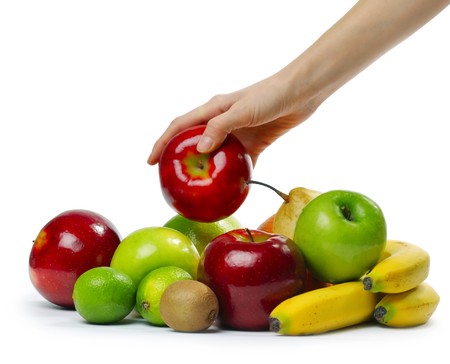 Hand with apple over heap of fruitsの写真素材