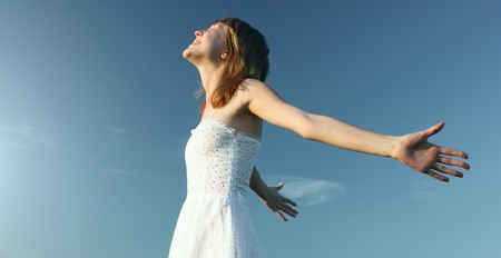 Young woman in white dress enjoying the sunの写真素材