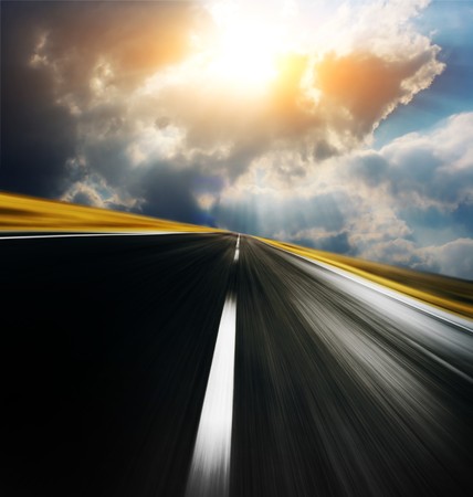 Empty asphalt blurry road with cloudy sky and sunlight の写真素材