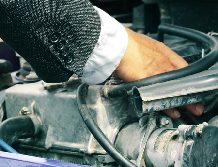 Repairing engine of a car. Focus on suit's buttonsの写真素材