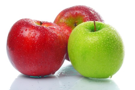 Three wet apples on glass surface over whiteの写真素材