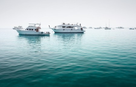 Boats on harbor with clear sea waterの写真素材