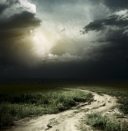 Rural road and dark storm cloudsの写真素材