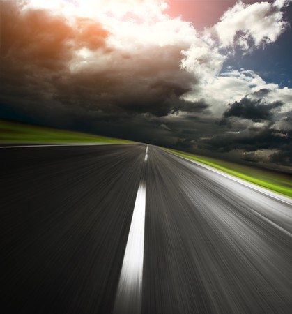 Empty asphalt road and cloudy sky with sunlightの写真素材