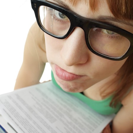 Young sad woman in broken retro glasses and heap of papersの写真素材