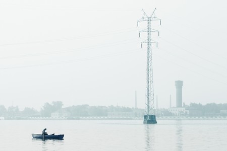 Alone man sitting in a boat in an industrial zoneの写真素材