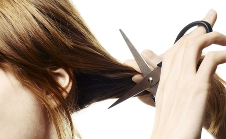 Woman going to cut her hair with scissorsの写真素材