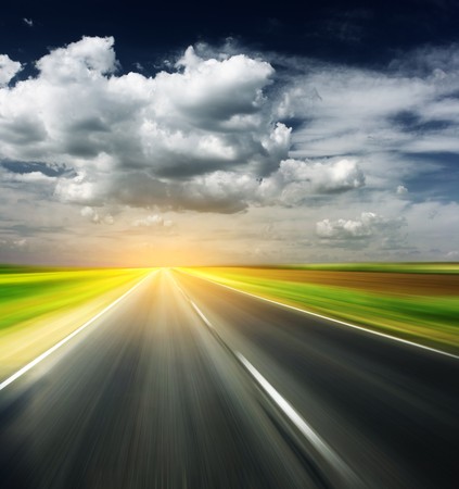 Blurred asphalt road and sky with cloudsの写真素材