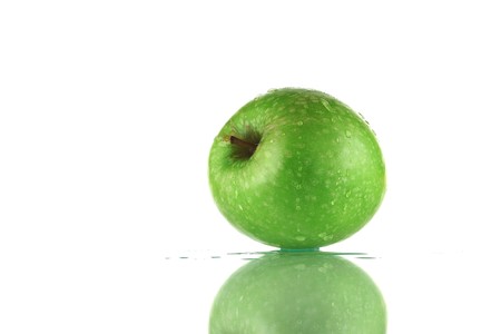 Green apple on white background and reflectionの写真素材