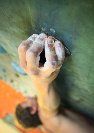 Young man climbing on indoor wallの写真素材