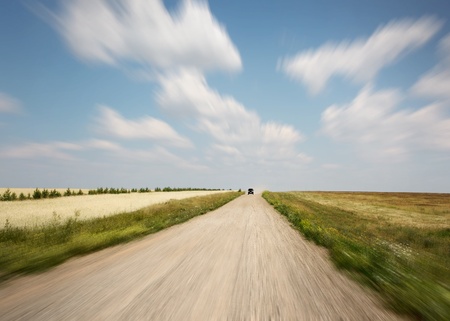 Rural motion blurred road and blue sky with summer clouds