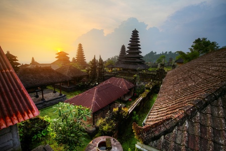 Yard with green trees and buildings of indonesian old temple Pura Besakih at sunset light