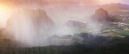 Tropical rain over valley with limestone mountains and forestsの写真素材