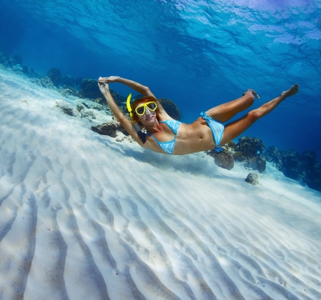 Young lady snorkeling in a transparent tropical sea over sandy bottomの写真素材