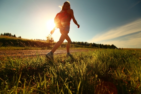 Hiker with backpack walking on a gravel roadの写真素材