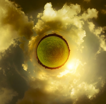 Panorama of a green meadow and sunset cloudy sky in a form of little planetの写真素材