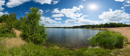 Coast of the pond with clear water at sunny dayの写真素材