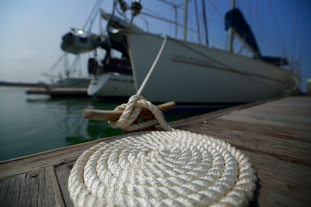 Coil of the rope on the wooden pier tied up to the yacht. Focus on the coil.の写真素材