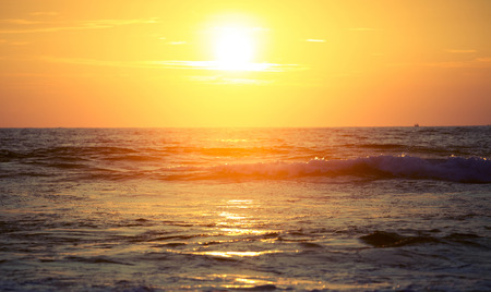 Sunset over sea with wavesの写真素材