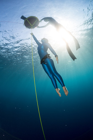 Free diver ascending along the ropeの写真素材