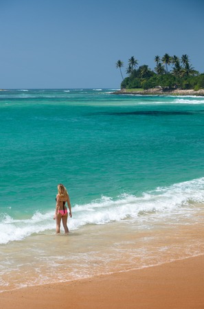Young lady going to swim in the tropical seaの写真素材